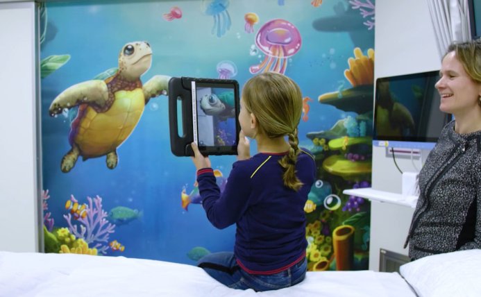 Een kind speelt met Storywall voordat het een operatie krijgt.