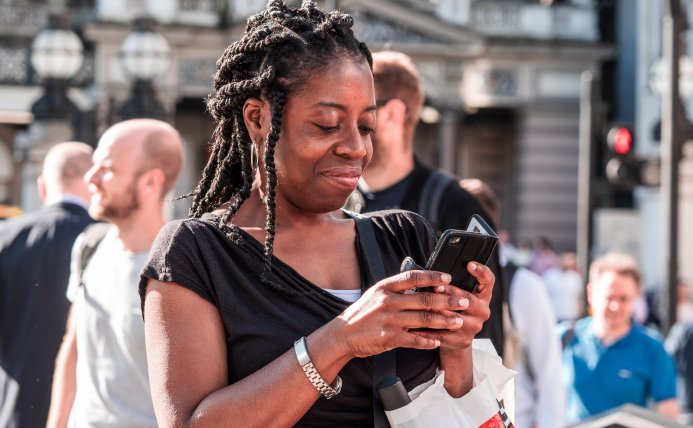 Vrouw op straat kijkt op smartphone