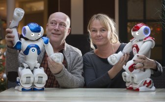 Bart Meussen en Mirjam van Blanken met twee Zora-zorgrobots