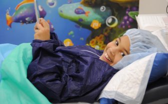 meisje ligt  met smartphone in ziekenhuisbed