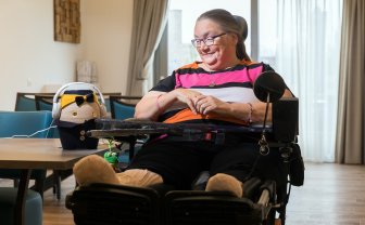 vrouw in rolstoel kijkt naar zorgrobot tessa