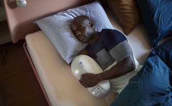 Man slaapt met slaaprobot in hand