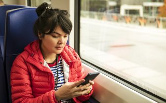 Vrouw in de trein kijkt op haar smartphone
