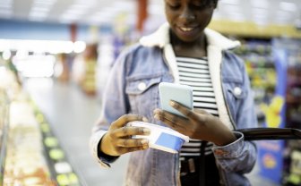 Vrouw scant zuivelproduct met haar smartphone om informatie te kunnen lezen