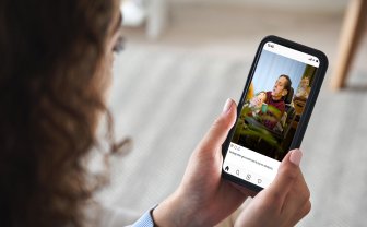 Vrouw kijkt op haar smartphone naar foto van demente moeder 