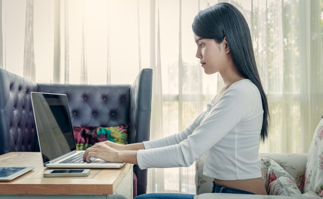 Vrouw achter laptop met rechte rug