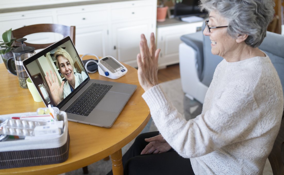 Oudere vrouw videobelt met dokter en heeft meetapparatuur bij de hand