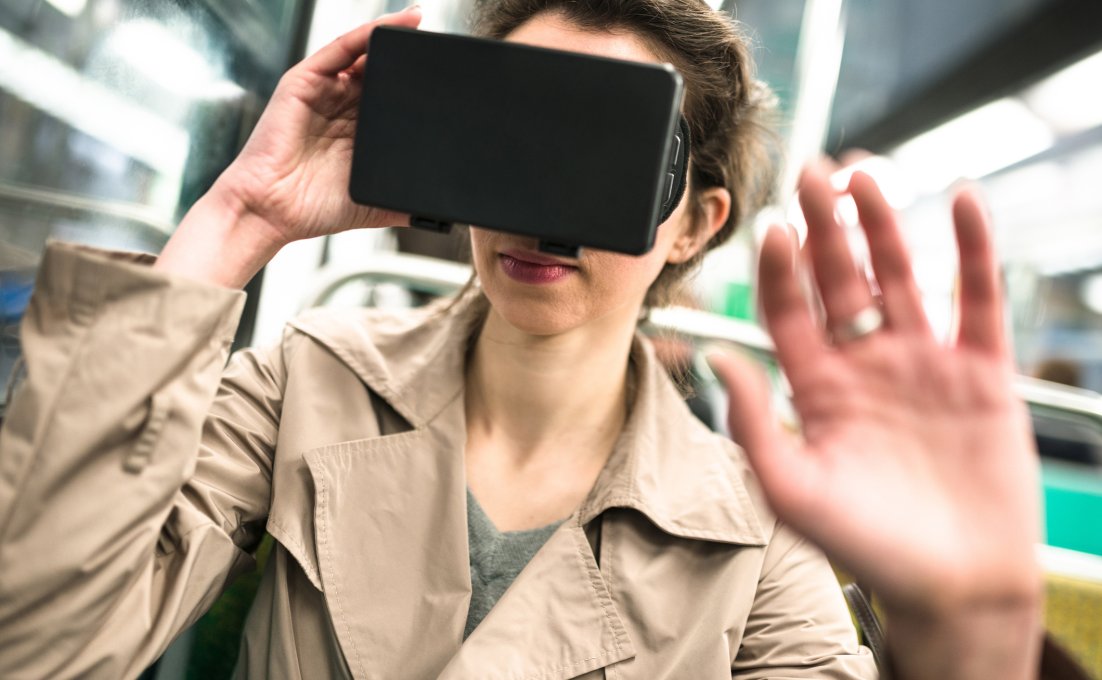 Vrouw met VR bril op kijkt angstig in het OV