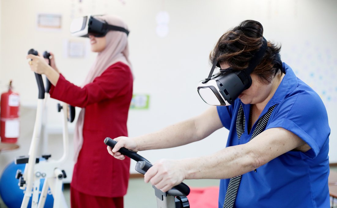Twee vrouwen met VR brillen op maken gebruik van diverse fitness aparaten