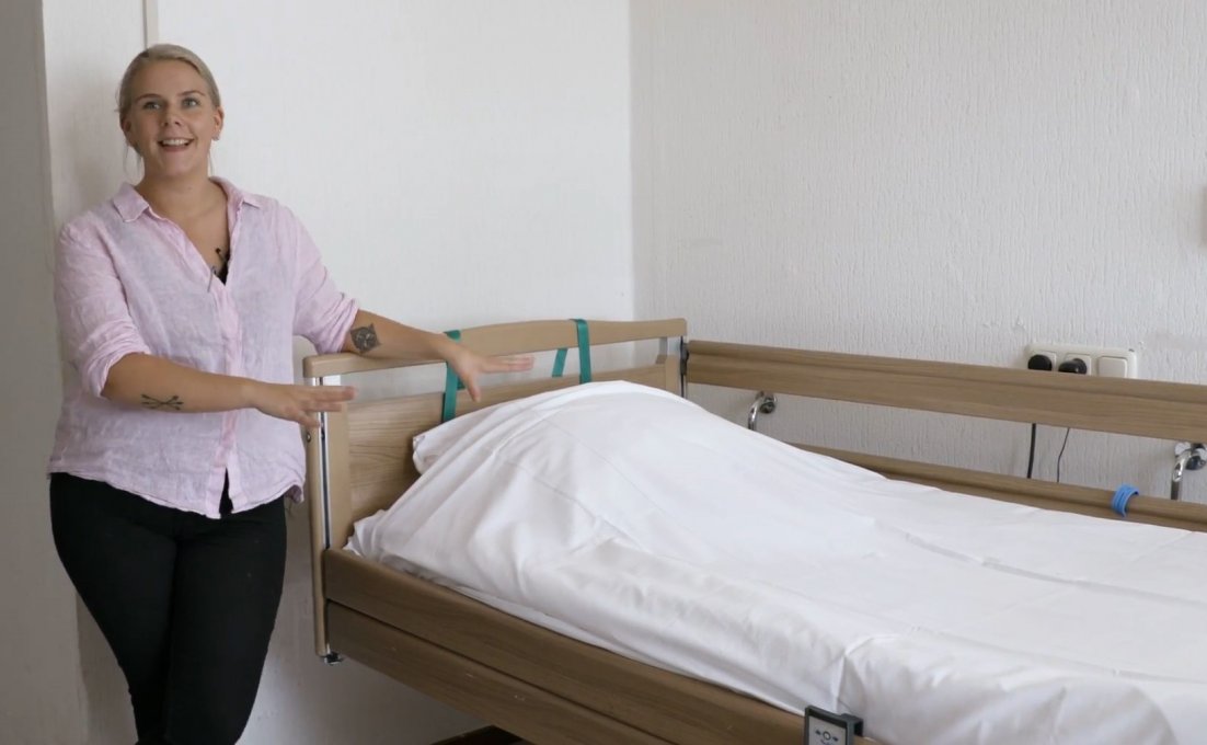 Vrouw staat naast slim bed met slim matras