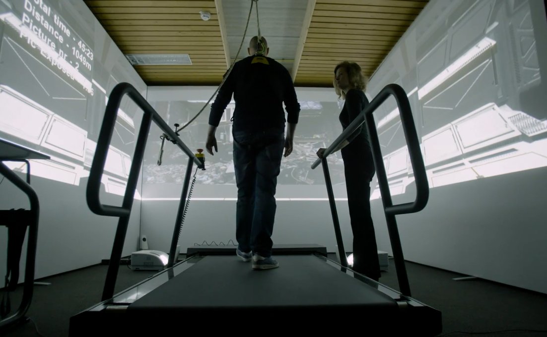 Man loopt op loopband en heeft drie schermen om zich heen met virtuele trauma beelden