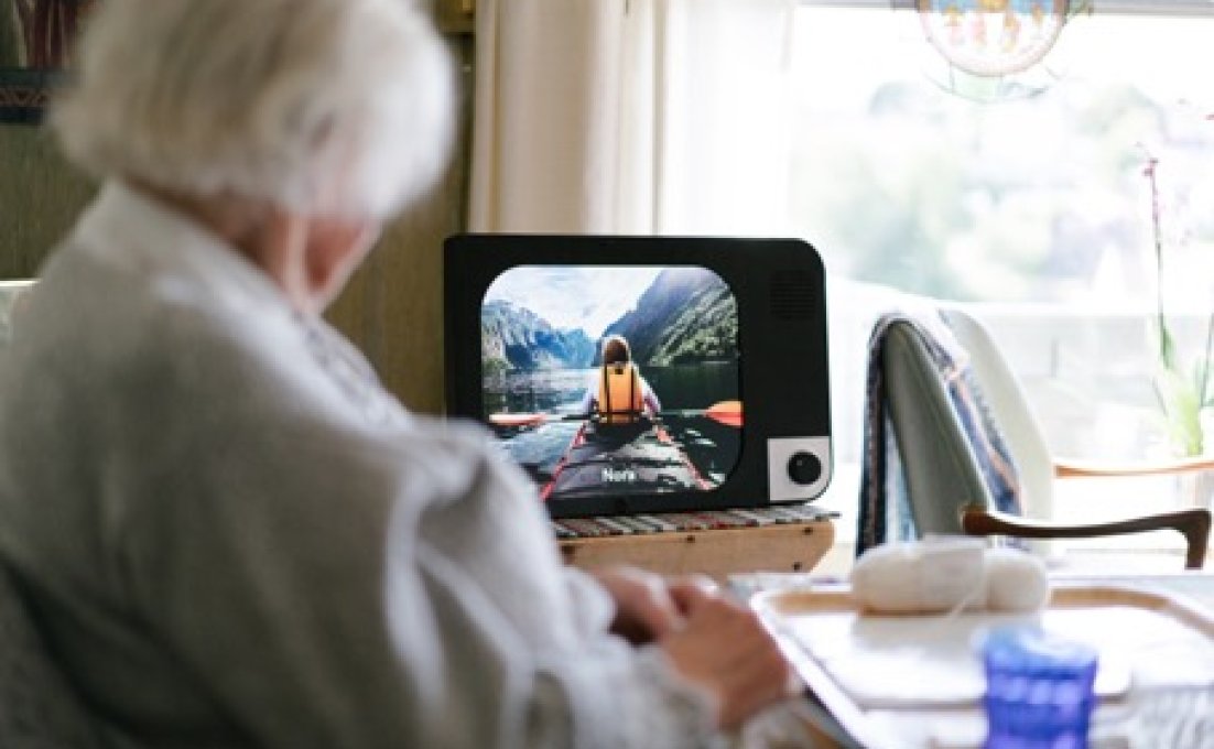 Oudere vrouw kijkt naar eenvoudige computer KOMP