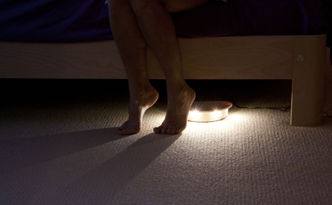 lampje onder bed verlicht voeten die uit bed stappen