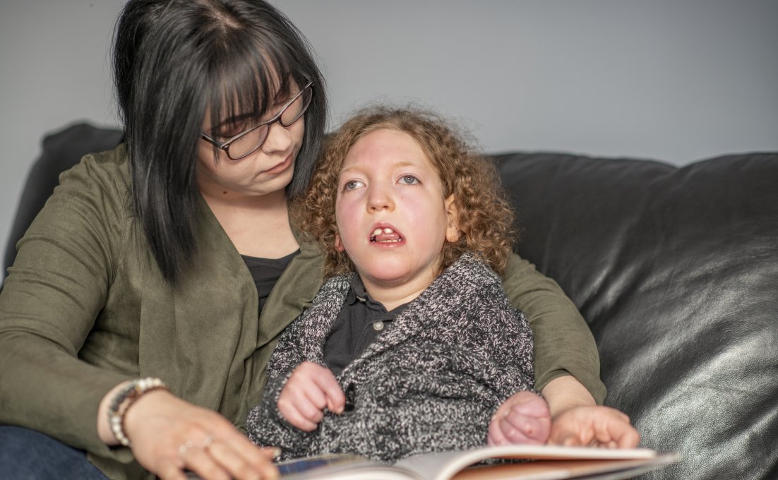 Moeder leest kind voor met cerebrale parese