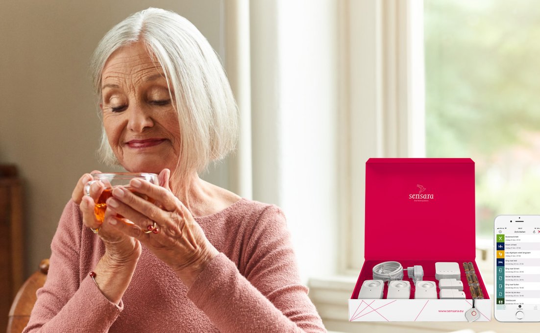 Oudere vrouw drinkt kopje thee met leefstijlmonitoring sensoren naast zich