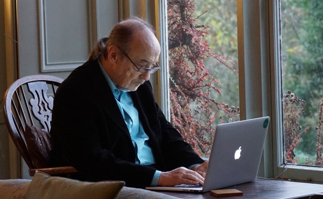 Oudere man kijkt op laptop