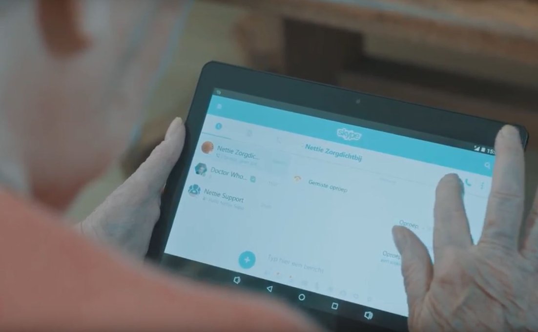 Oudere vrouw gebruikt Virtuele Thuiszorg en tikt op tabletscherm om Nettiezorg te bellen