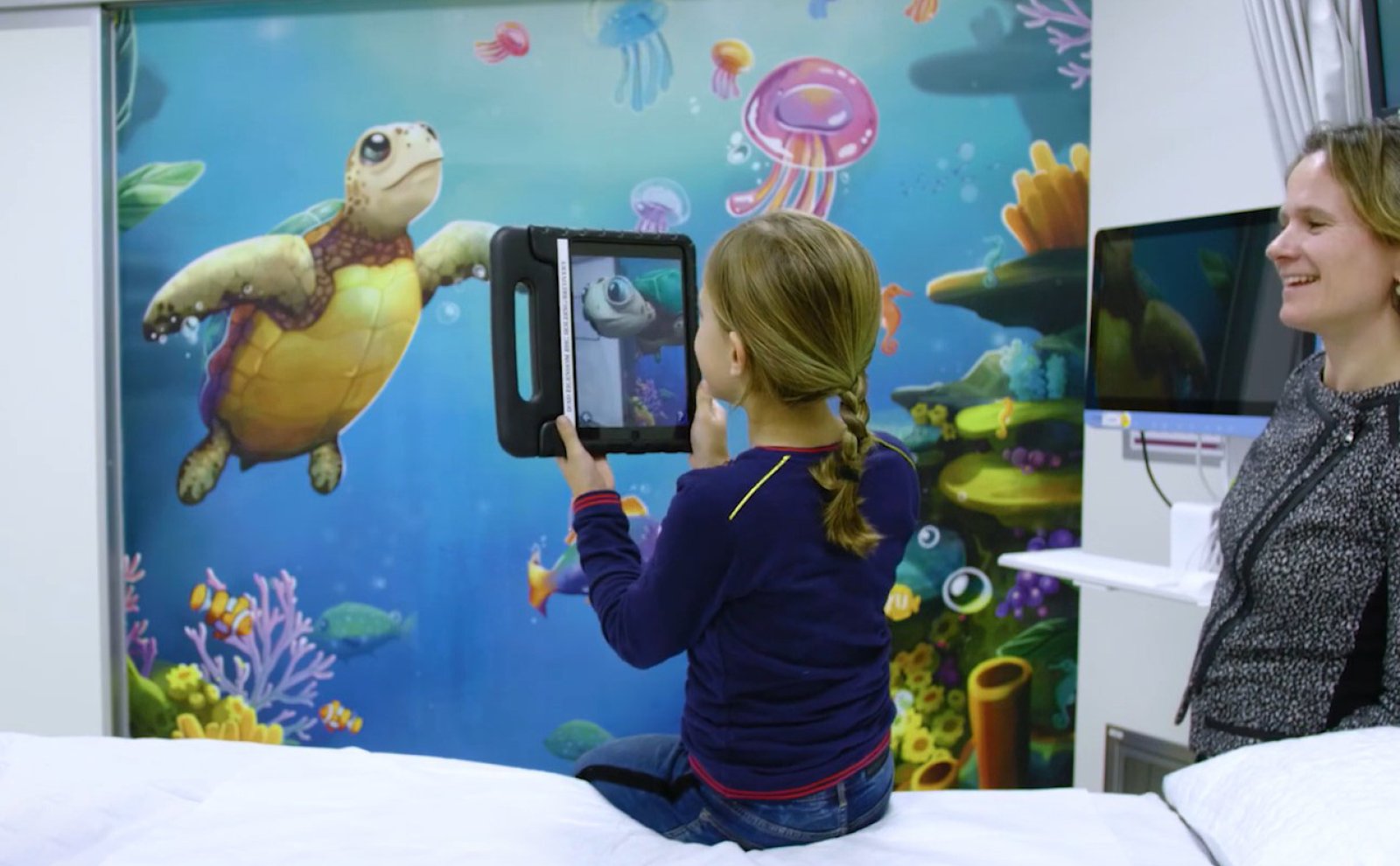 Een kind speelt met Storywall voordat het een operatie krijgt.